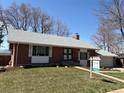 Brick home with gray shingles, white trim, and a 'For Sale' sign on the lawn at 7055 S Costilla St, Littleton, CO 80120