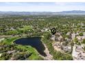 Scenic aerial view showcases the property's location near a pond and surrounded by lush greenery at 6862 Independence Ct, Arvada, CO 80004