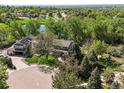 Stunning aerial view of a landscaped home nestled amongst lush trees and landscaping near a pond at 6862 Independence Ct, Arvada, CO 80004