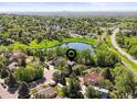 Breathtaking aerial view showcasing a home's location within a lush neighborhood and near a tranquil pond at 6862 Independence Ct, Arvada, CO 80004