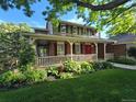 Charming two-story home with manicured lawn, inviting porch, and garden bed at 6862 Independence Ct, Arvada, CO 80004