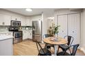 Modern kitchen with stainless steel appliances, white cabinets, and adjacent dining area for convenient meals at 7114 S Acoma Way, Littleton, CO 80120
