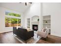 Bright living room with fireplace, built-in shelving, and large windows offering ample natural light at 7114 S Acoma Way, Littleton, CO 80120