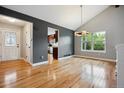 Open dining room with hardwood floors, a modern chandelier, and a view into the kitchen at 8174 Dudley Cir, Arvada, CO 80005