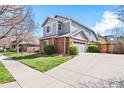 Featuring an expansive driveway, a two-car garage, and a basketball hoop next to the property's manicured lawn at 134 S Pontiac St, Denver, CO 80230