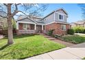 Charming two-story home with brick and gray siding, a manicured lawn, and a cozy front porch at 134 S Pontiac St, Denver, CO 80230