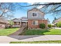 Two-story home featuring a manicured lawn, brick accents, mature trees, and a walkway to the front door at 134 S Pontiac St, Denver, CO 80230