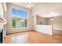 Spacious living room featuring a fireplace, large window offering lots of natural light, and beautiful hardwood floors at 11862 W Stanford Pl, Morrison, CO 80465