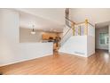 Open concept living room with hardwood floors, staircase and kitchen view, perfect for Gathering gatherings and entertaining at 11862 W Stanford Pl, Morrison, CO 80465