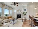 Sun-filled living room with fireplace, large windows, modern furnishings, and hardwood floors at 16550 Umatilla Pl, Broomfield, CO 80023