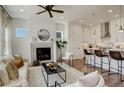 Spacious living room with fireplace open to the kitchen with modern decor and hardwood floors at 16550 Umatilla Pl, Broomfield, CO 80023