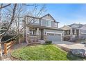 Two-story house with gray siding, stone accents, and a two-car garage at 3087 Black Canyon Way, Castle Rock, CO 80109