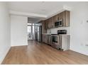 Modern kitchen with stainless steel appliances and wood cabinets at 3575 Chestnut Pl # 406, Denver, CO 80216