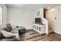 Bright living room with stylish vinyl flooring, a gray sectional and adjacent stairway at 1353 Reynolds St # 2B, Fort Lupton, CO 80621
