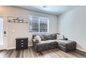 Cozy living room with a comfortable gray sectional, window, and modern decor at 1353 Reynolds St # 2B, Fort Lupton, CO 80621