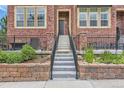 Inviting townhouse with well-manicured front garden and stairs with sleek black iron railings leading to entrance at 9424 Ridgeline Blvd # I, Highlands Ranch, CO 80129