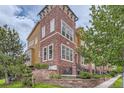 Charming townhome features brick facade, landscaped front yard, and inviting entry steps with iron railings at 9424 Ridgeline Blvd # I, Highlands Ranch, CO 80129