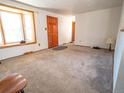 Bright and spacious living room with large bay window, carpet, and wood-paneled door at 1501 E Caley Ave, Centennial, CO 80121