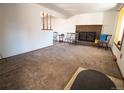 Cozy living room features a brick fireplace, neutral carpet, and a staircase with wood banister at 1501 E Caley Ave, Centennial, CO 80121