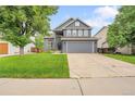 Charming two-story home with a well-maintained lawn, mature tree and a two car garage at 8838 S Dudley St, Littleton, CO 80128