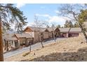 Long driveway to a beautiful ranch-style home with garage and side entrance, surrounded by trees at 12653 Rancho Ct, Conifer, CO 80433