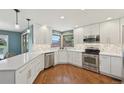 Stylish kitchen featuring white cabinets, stainless steel appliances and hardwood floors at 9977 Falcon Creek Dr, Highlands Ranch, CO 80130
