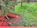 Multi-level red staircase descends into a lush backyard, offering a private outdoor retreat at 29983 Hilltop Dr # 2, Evergreen, CO 80439