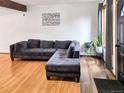 Cozy living room with a plush gray sectional sofa, complemented by wood floors and bright natural light at 29983 Hilltop Dr # 2, Evergreen, CO 80439