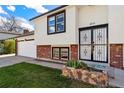 Close up of the front entrance with tidy landscaping and brick accents at 5031 Upton Ct, Denver, CO 80239