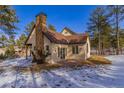 Back exterior view of house with patio and snowy yard at 590 Cumberland Rd, Larkspur, CO 80118