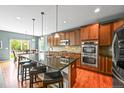 Modern kitchen featuring dark cabinets, granite countertops, a kitchen island, and stainless steel appliances at 5238 Gould Cir, Castle Rock, CO 80109