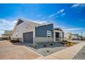 Attractive home featuring a blue and gray exterior, brick driveway, stone accents, and a well-manicured front yard at 5150 N Quemoy Ct, Aurora, CO 80019
