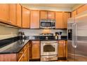 Modern kitchen with stainless steel appliances, sleek black countertops and light wood cabinets at 9019 E Panorama Cir # D207, Englewood, CO 80112