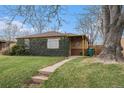 Charming brick home with lush ivy covering the facade and a well-manicured front yard at 2784 W 4Th Ave, Denver, CO 80219