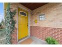 Inviting front entrance with a bright yellow door, brick facade, and decorative details at 2784 W 4Th Ave, Denver, CO 80219