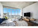 Bright living room featuring floor-to-ceiling windows with city views, modern furniture, and hardwood floors at 891 14Th St # 3415, Denver, CO 80202