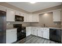 Bright kitchen featuring white cabinetry, dark appliances, and gray countertops at 11894 Elk Head Range Rd, Littleton, CO 80127