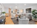 Bright living room featuring stylish furniture, hardwood floors, and an open layout to the kitchen at 3912 S Acoma St, Englewood, CO 80110