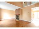Spacious living room with wood floors, a cozy fireplace, and plenty of natural light at 19421 E Milan Cir, Aurora, CO 80013