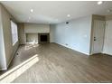 Living room with light-colored wood-look flooring and fireplace insert in light-colored decorative box above at 10117 Granby St, Commerce City, CO 80022