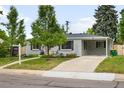 Attractive single-story home featuring a covered carport and concrete driveway, complemented by a well-kept lawn at 5740 S Cherokee St, Littleton, CO 80120