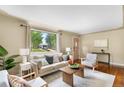 Comfortable living room featuring hardwood floors, natural light, and stylish, neutral-toned furniture at 5740 S Cherokee St, Littleton, CO 80120