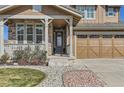 Inviting home exterior featuring stone accents, a covered porch, and manicured landscaping with a three-car garage at 15705 Red Deer Dr, Morrison, CO 80465