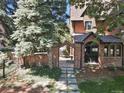 Charming brick home with a stone pathway and arched entrance, framed by mature trees and greenery at 6330 Montview Blvd, Denver, CO 80207