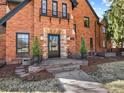 Brick Tudor style home with a stone entry, detailed trim, and a well-manicured lawn at 6330 Montview Blvd, Denver, CO 80207