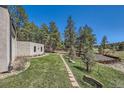 Expansive backyard featuring a well-manicured lawn, a pathway, mature trees, and a beautiful view at 1559 Apex Rd, Franktown, CO 80116