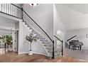 Elegant foyer with a grand staircase, hardwood floors, high ceilings, and a glimpse of a formal dining area at 10345 Lions Heart, Lone Tree, CO 80124