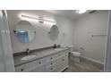 Modern bathroom with dual sinks, granite counters, modern lighting, and round mirrors at 100 E Highline Cir # 307, Centennial, CO 80122