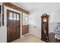 Foyer features brick accent wall, wooden door, and a vintage grandfather clock at 1074 S Corona St, Denver, CO 80209