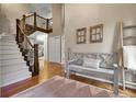 Welcoming entryway featuring wood floors, a staircase with iron railings, and a gray bench with decorative pillows at 4220 S Yarrow Ct, Lakewood, CO 80235